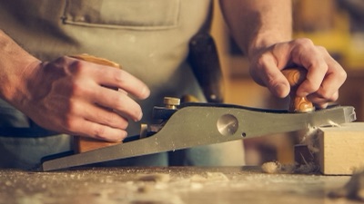 Craftsman hand-planing solid timber